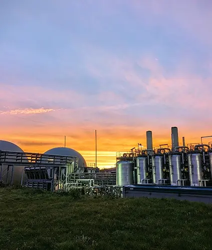 A factory plant with a sunset in the background