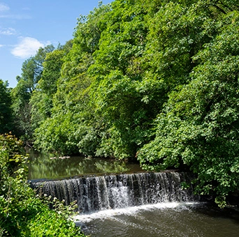 man walking through a river with water proof high boots